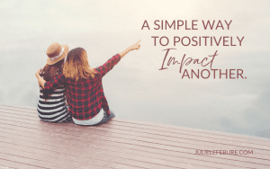 Simple Way to Positively Impact Another | two women sitting on dock, one pointing away