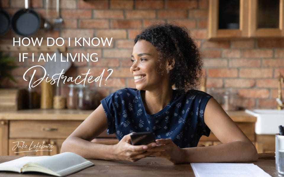 How Do I Know if I Am Living Distracted? | woman sitting at table looking off to the side with a smile