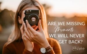 Are We Missing Moments We Will Never Get Back | woman in rust-colored sweater looking through camera lens, focusing camera and facing forward towards camera