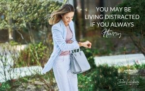 You May Be Living Distracted if You Always Hurry | woman in light blue jacket and jeans looking down at watch in a hurry