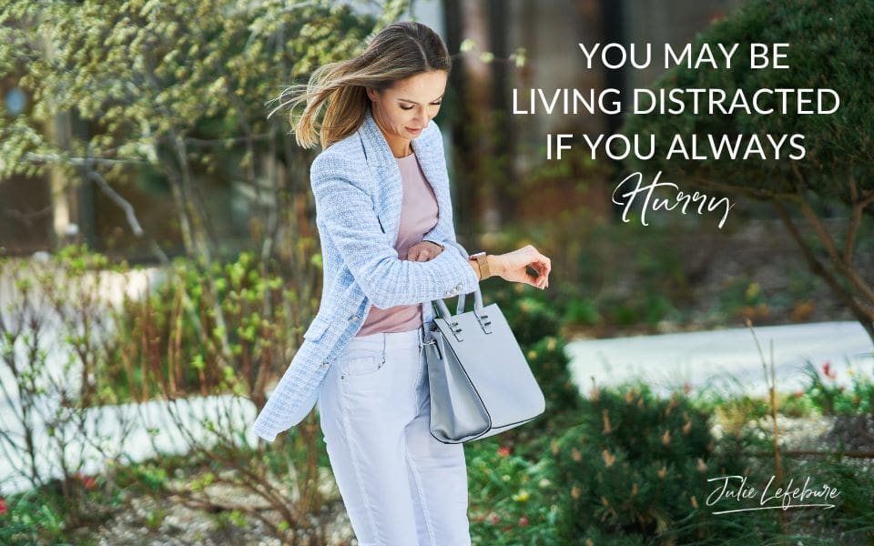 You May Be Living Distracted if You Always Hurry | woman in light blue jacket and jeans looking down at watch in a hurry