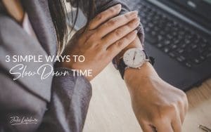 3 Simple Ways to Slow Down Time | woman's hand pulling back gray suit sleeve of other hand to see her wristwatch